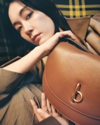 Asami holding Rocking Horse Bag in colour Hazel