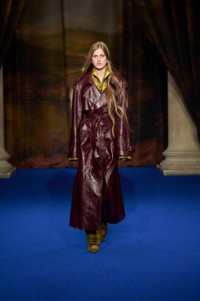 Iris Lasnet indossa un trench in elaborata pelle goffrata marrone, camicia stile pigiama e pantaloni pear yellow, ciabatte Cameo cub brown e orecchini Star.